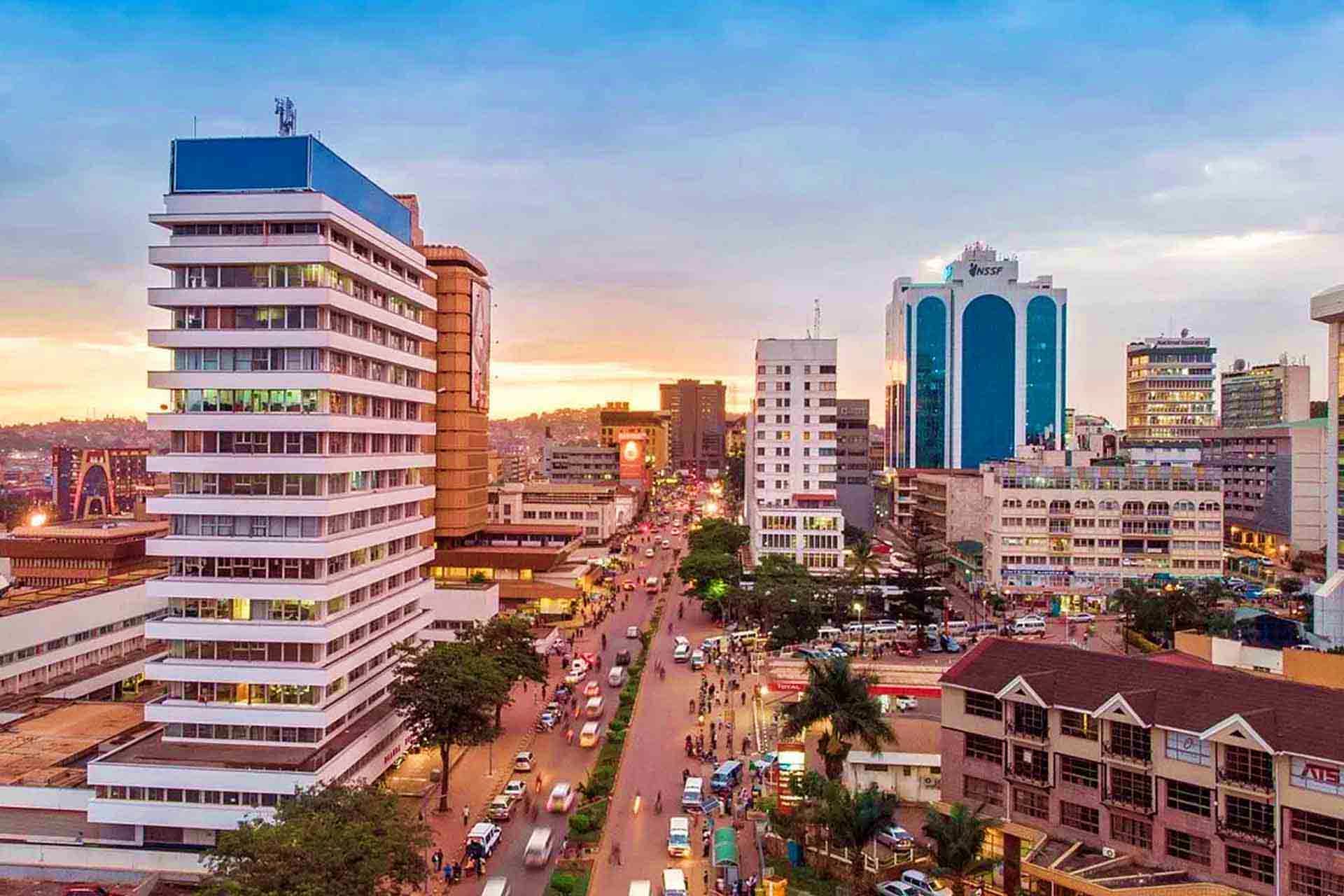 Kampala city skyline at sunset with modern office buildings and bustling downtown street traffic